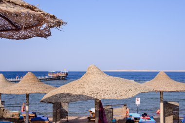 Thatched plaj şemsiyeleri bir tropikal tatil