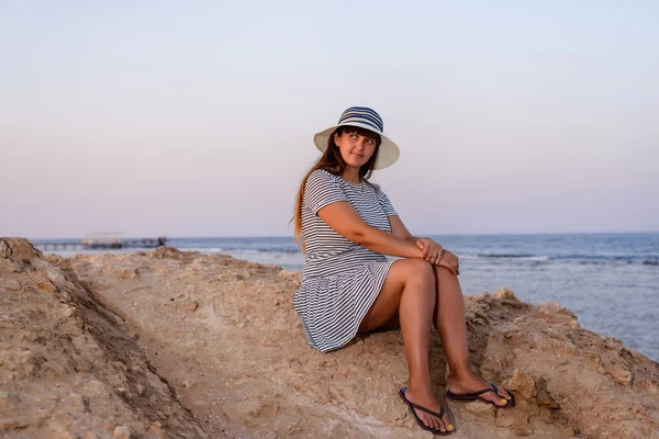 Romantic woman enjoying the breeze at the seaside — Stockfoto