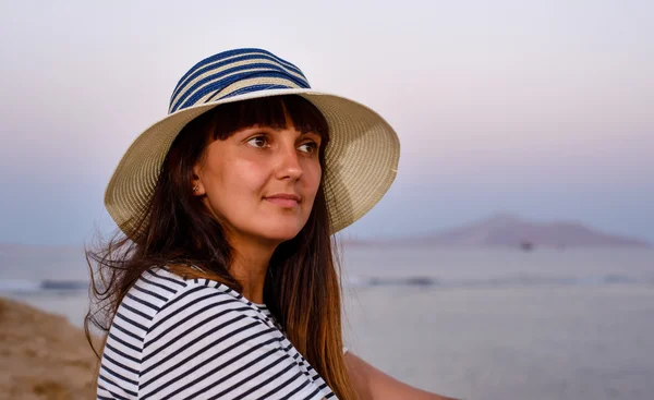 Όμορφη γυναίκα στην παραλία καπέλο να χαμογελά στη φωτογραφική μηχανή — Φωτογραφία Αρχείου
