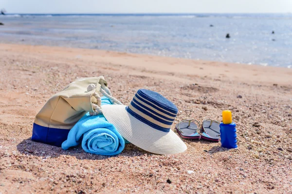 Torba plażowa i niedz kapelusz na słoneczny bezludnej plaży — Zdjęcie stockowe