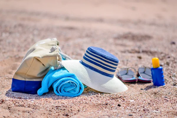 Sac de plage et chapeau de soleil sur la plage de sable ensoleillée — Photo