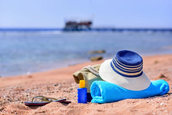 Bolsa de playa y sombrero de sol en Sunny Deserted Beach —  Fotos de Stock