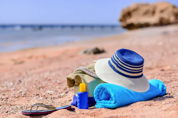 Strandväska och solhatt på soliga öde strand — Stockfoto