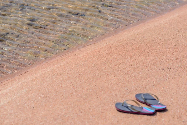 Paar van Flip Flops op kustlijn van Sandy Beach — Stockfoto