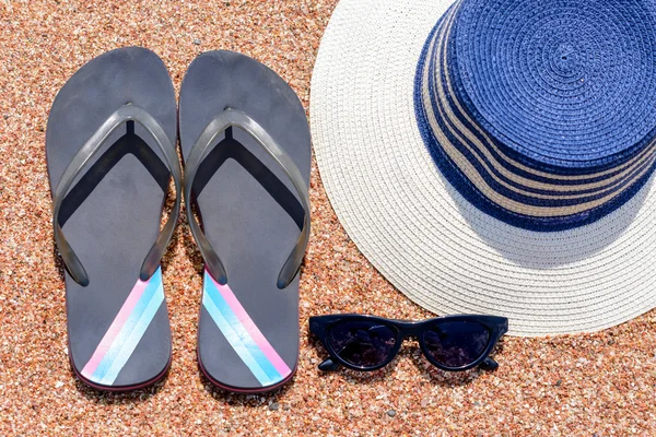 Óculos de sol, Slip slops e chapéu de sol em uma praia tropical — Fotografia de Stock