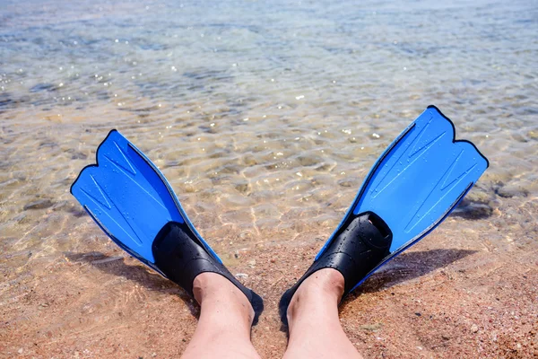 Person mit Flossen liegt am Rande des Meeres — Stockfoto