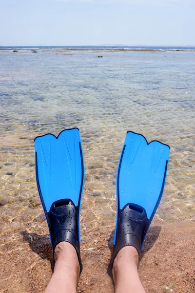 Person som bär fenor ligga på kanta av havet — Stockfoto