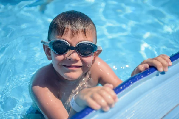 Smiling young boy in a swimming pool — Stock Photo, Image