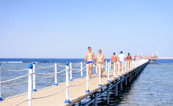 Tourists walking across a wooden pier — Stock Photo, Image