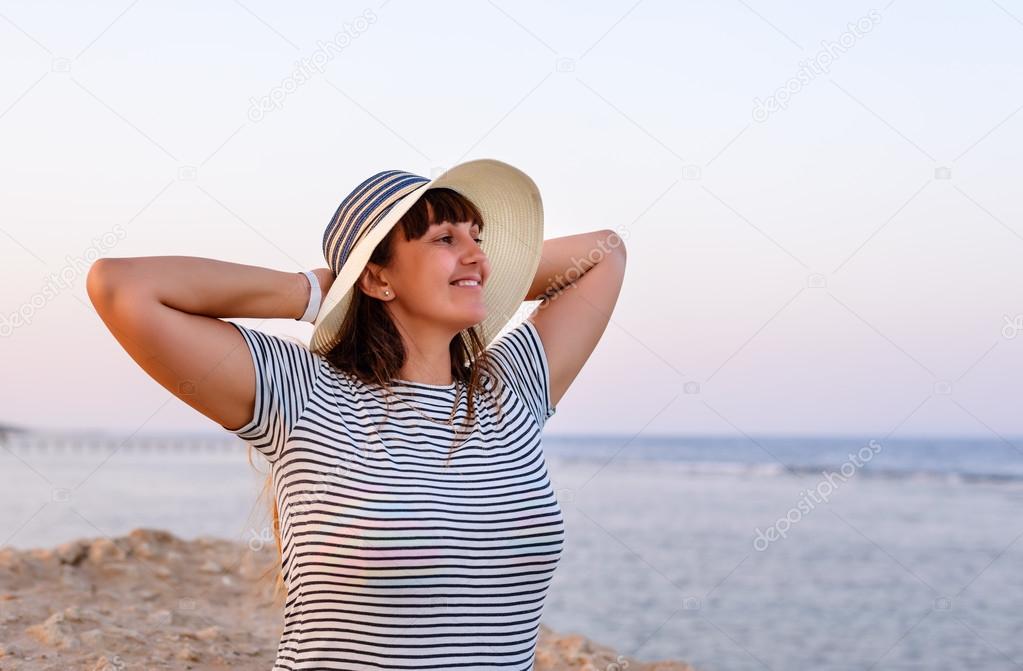 Woman Standing with Hands Behind Head on Beach