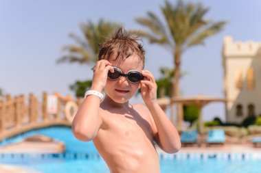 Yüzmeye gitmek için genç çocuk gözlük koyarak