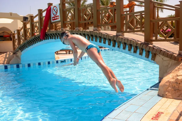 Pequeño niño buceando en una piscina del complejo —  Fotos de Stock