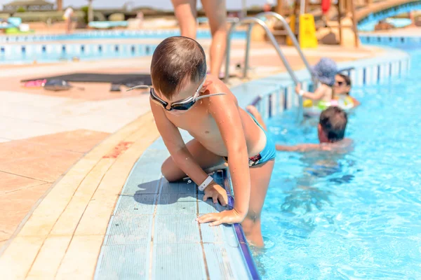 Petit garçon grimpant hors d'une piscine — Photo