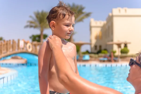 Schattige kleine jongen met zonnebrandcrème toegepast — Stockfoto