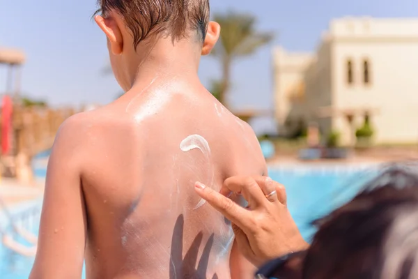 Jeune garçon avec écran solaire sur le dos — Photo