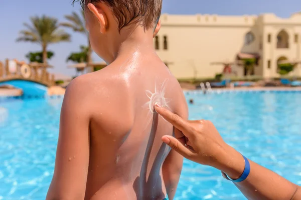 Mother drawing a sun on her sons back — Stockfoto