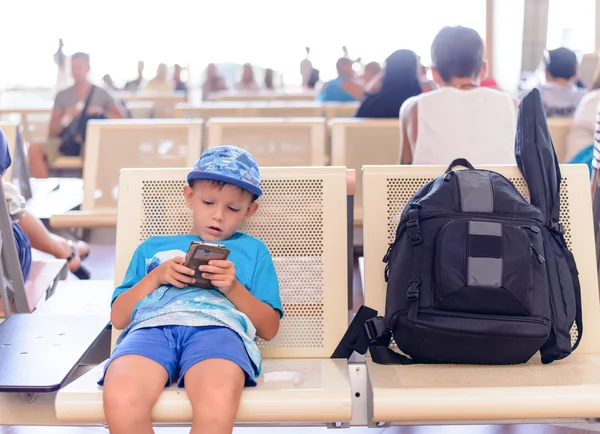 Young boy sitting in an airport terminal — Stockfoto
