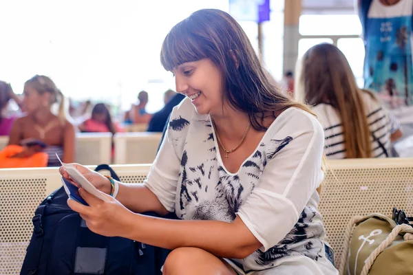 Woman checking her passport in an airport terminal — ストック写真