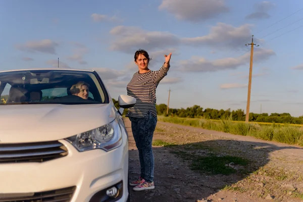 Woman pointing out the way to a female driver — Stock Photo, Image