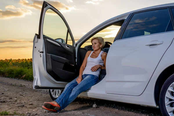 Woman sitting waiting for roadside assistance — ストック写真