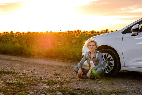 Woman waiting beside her car on a rural road — Stockfoto