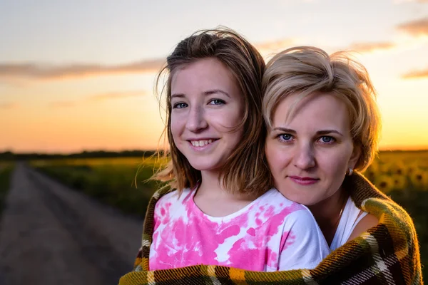 Mãe e filha na estrada do campo ao pôr do sol — Fotografia de Stock