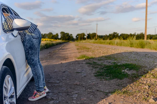 Kvinna att nå inne i det öppna fönstret av en bil — Stockfoto