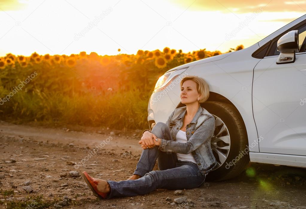 Woman parked at the roadside at sunset