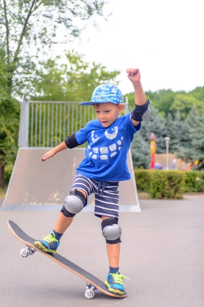 Lycklig pojke tränar balanserar på en skateboard — Stockfoto