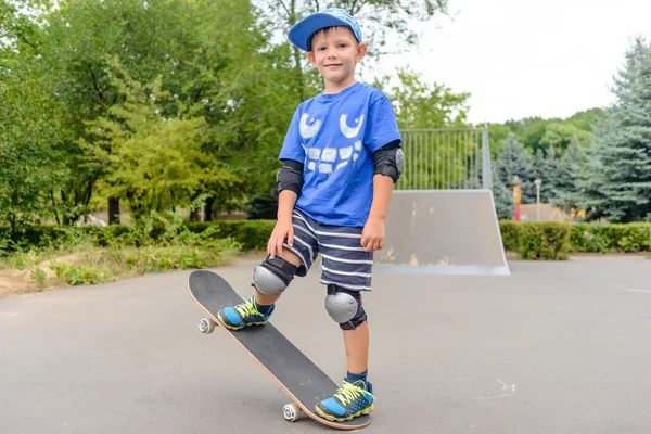Rapaz feliz praticando equilíbrio em um skate — Fotografia de Stock