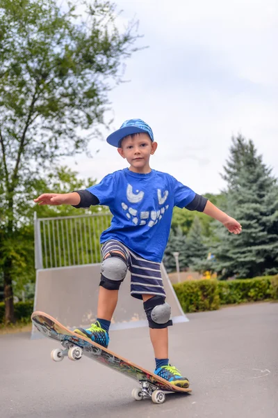 Szczęśliwy chłopiec praktykujących, balansując na deskorolce — Zdjęcie stockowe