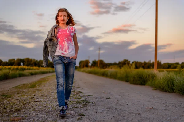 Young girl taking an evening walk in the country — Stock Photo, Image