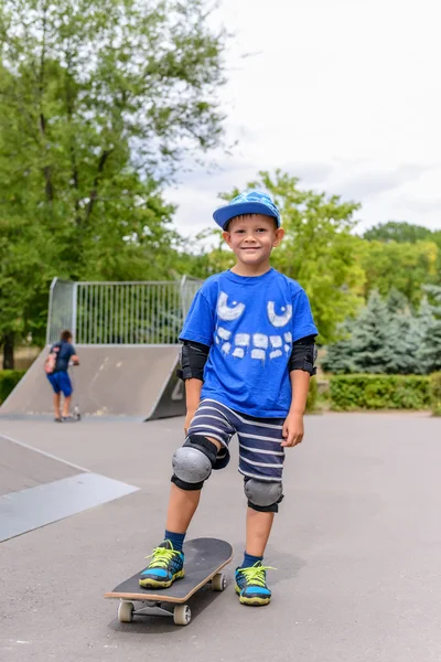 Piccolo ragazzo in piedi sul suo skateboard — Foto Stock