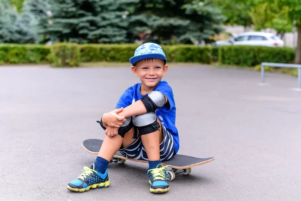 Bonito menino feliz em seu skate — Fotografia de Stock
