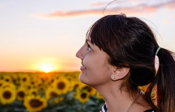 Mulher atraente desfrutando de um pôr do sol rural — Fotografia de Stock