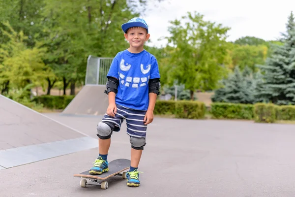 Menino pequeno de pé em seu skate — Fotografia de Stock