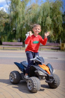 Küçük çocuk bir quad bisiklet üzerinde eğleniyor