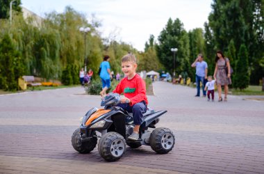 Küçük çocuk bir quad bisiklet üzerinde eğleniyor