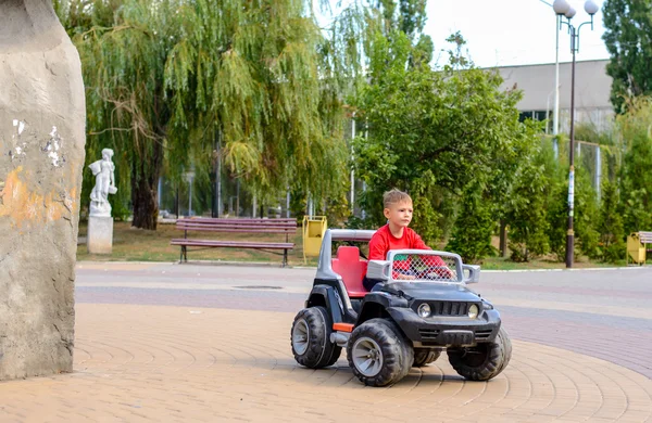 Niedlicher kleiner Junge am Steuer eines Spielzeug-Lastwagens — Stockfoto