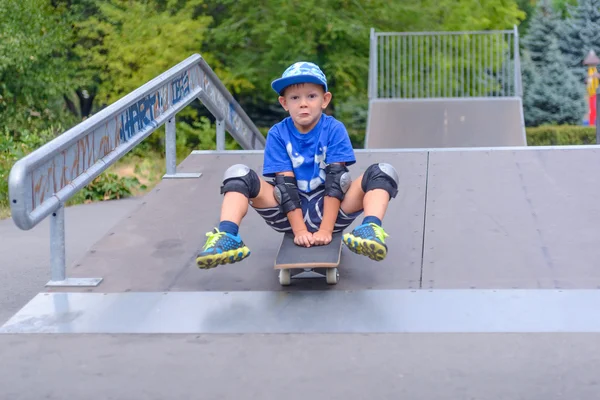 Aufgeregter kleiner Junge probiert sein neues Skateboard aus — Stockfoto