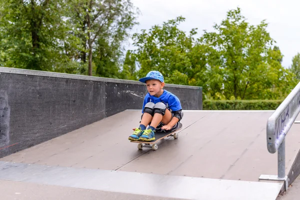 Petit garçon excité essayant sa nouvelle planche à roulettes — Photo