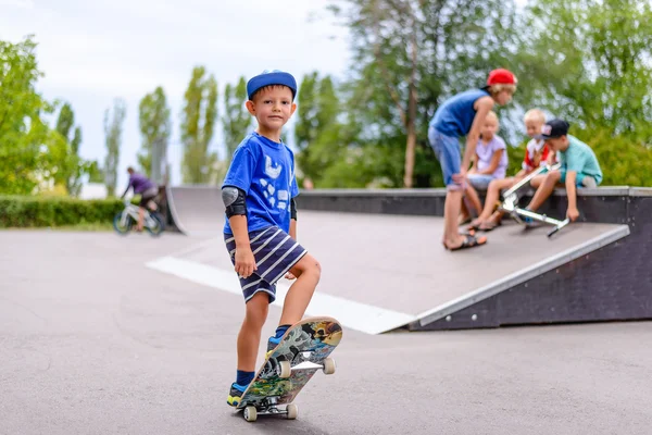 Young boy at a skate park with friends — Stock Photo, Image