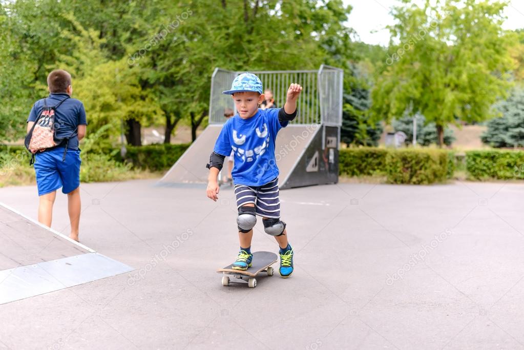 Cute small boy learning to skateboard