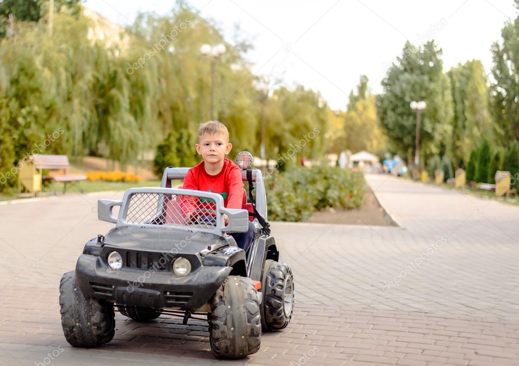Cute little boy driving a toy truck