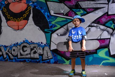 Handsome little boy holding his skateboard