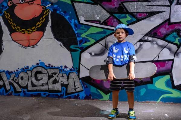 Handsome little boy holding his skateboard — Stockfoto