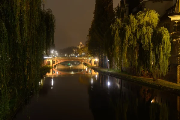 Освещённый мост через реку в городе — стоковое фото