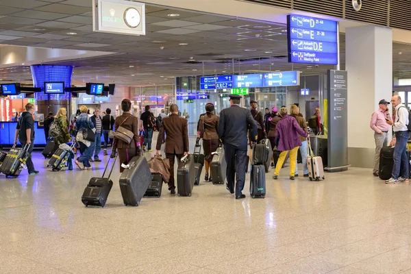 Passagerare som köar för att checka in på en flygplats — Stockfoto