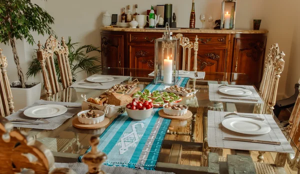 Pronto para comer tomates com queijo, caracóis e pão em uma mesa em um belo interior de casa — Fotografia de Stock