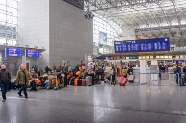 Passengers waiting in a departures hall clipart